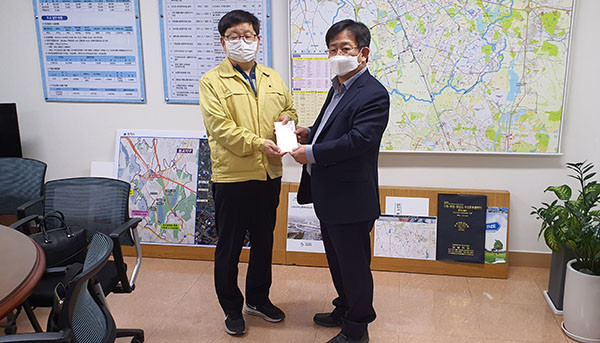 이정섭 팔달구 마을만들기협의회장(오른쪽)이 김용덕 수원시 안전교통국장에게 성금을 전달하고 있다. ⓒ경기타임스