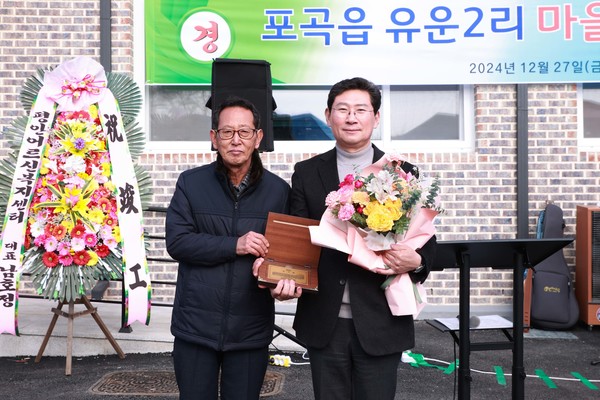 사진설명- 이상일 용인특례시장이 27일 포곡읍 유운2리 마을회관 준공식에서 팔당 상수원 상류지역으로 규제를 받아온 포곡읍 유운2리 주민들로부터 수변구역 해제를 위한 공로에 대한 감사한 마음을 담은 감사패를 받았다.ⓒ경기타임스