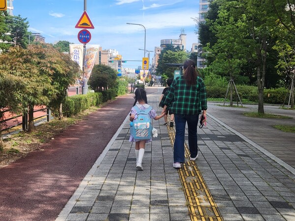 ‘초등 저학년 등하교 동행돌봄 서비스’로 아이와 동행하고 있는 새빛돌보미.ⓒ경기타임스