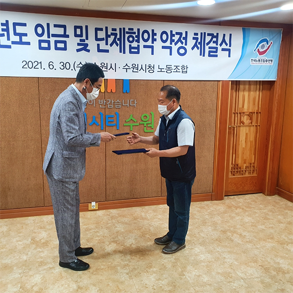 사진)김기배 환경국장(왼쪽)이 김성복 노동조합위원장과 협약서를 교환하고 있다.   ⓒ경기타임스